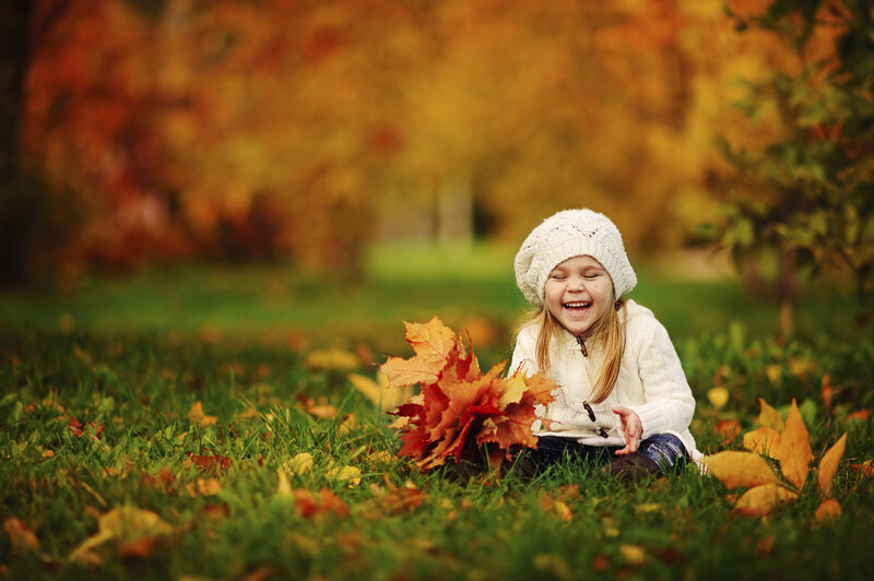 Girl Sitting in Autumn Leaves