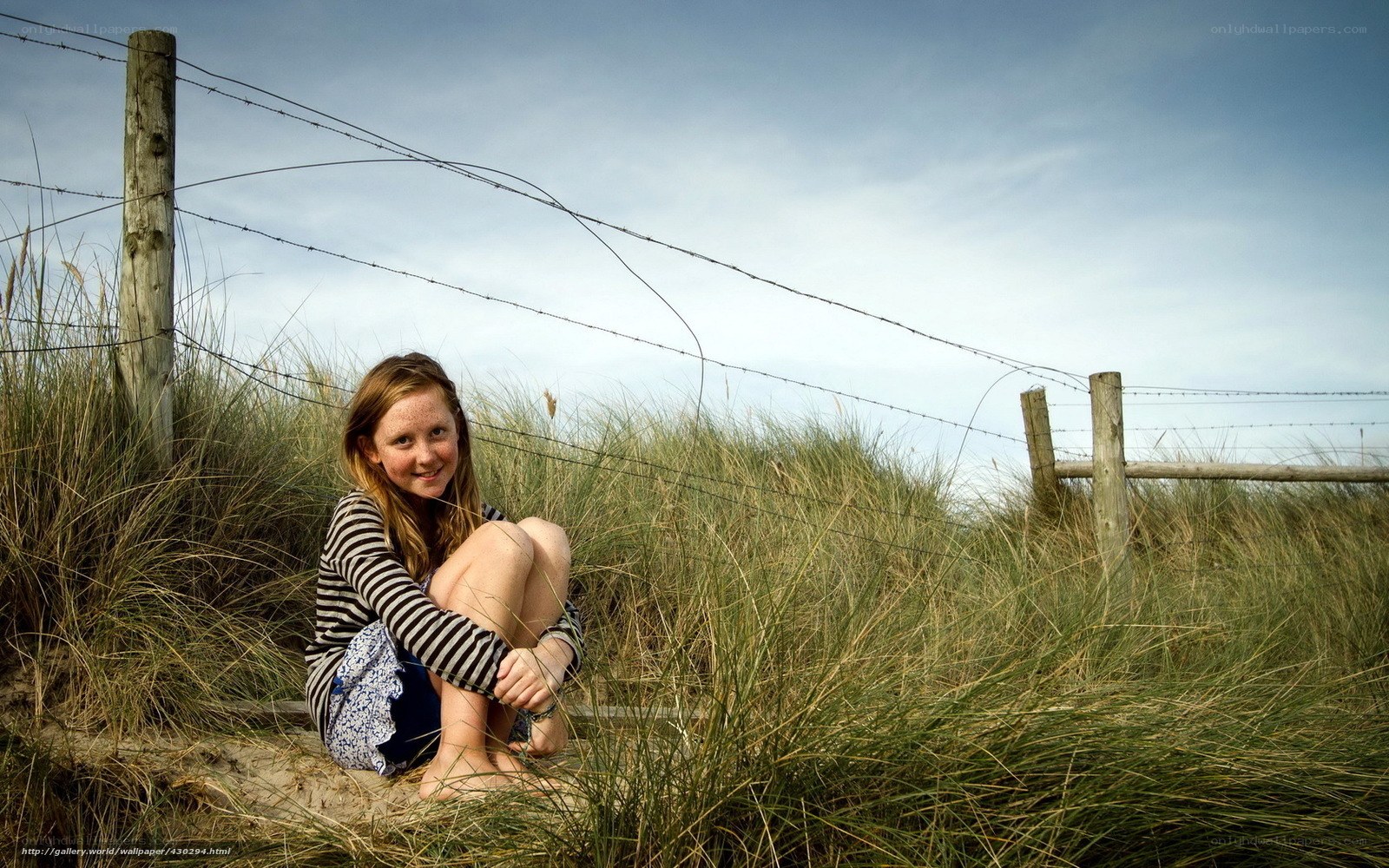 Girl sitting in dune grass