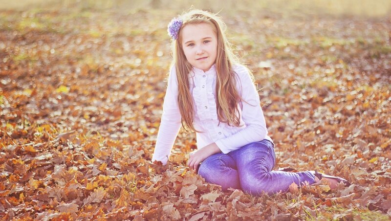Girl Sitting in Leaves — Brown