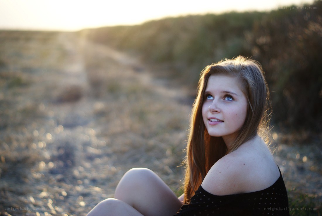 girl sitting on a path at sunset