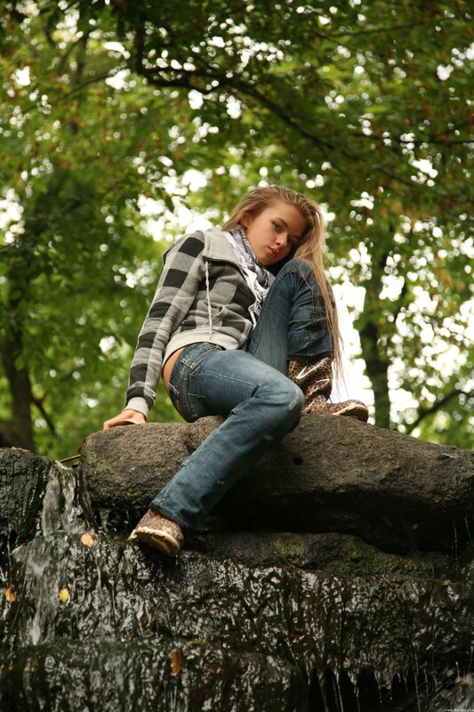 Girl sitting on a rock by water