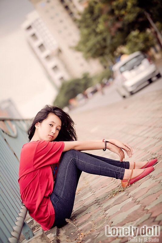 girl sitting on a sidewalk