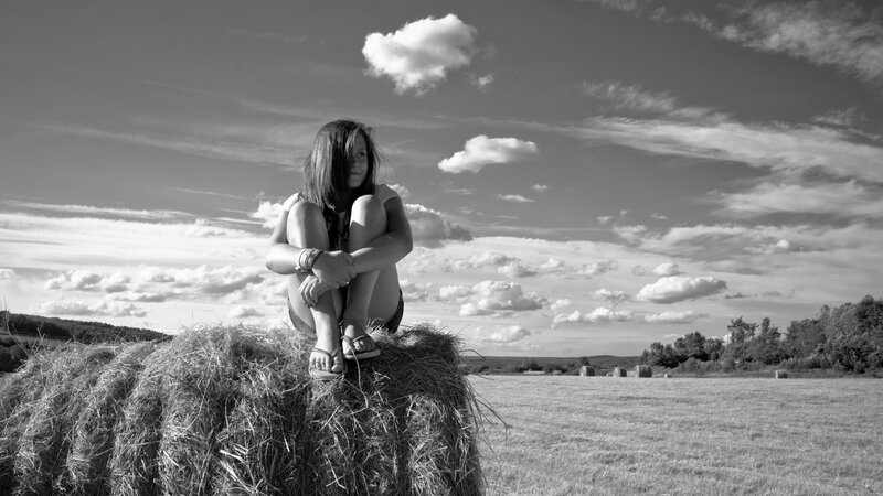 Girl sitting on hay bale
