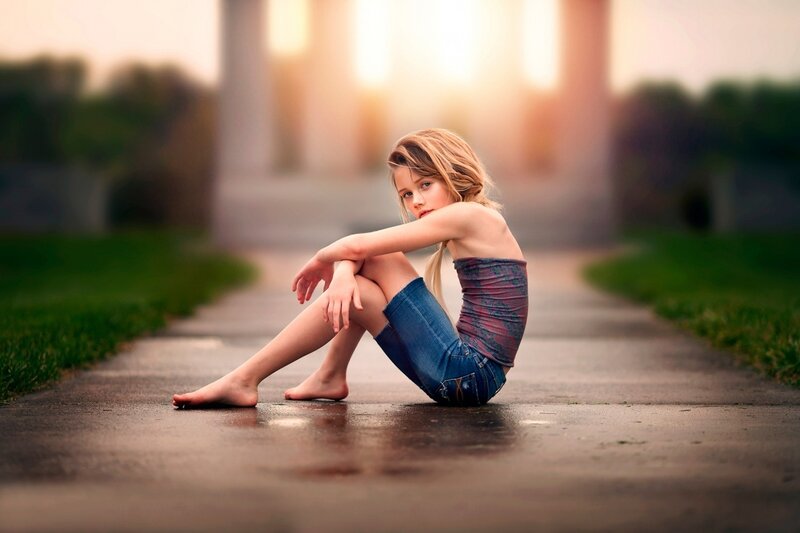Girl Sitting on Pavement — Brown