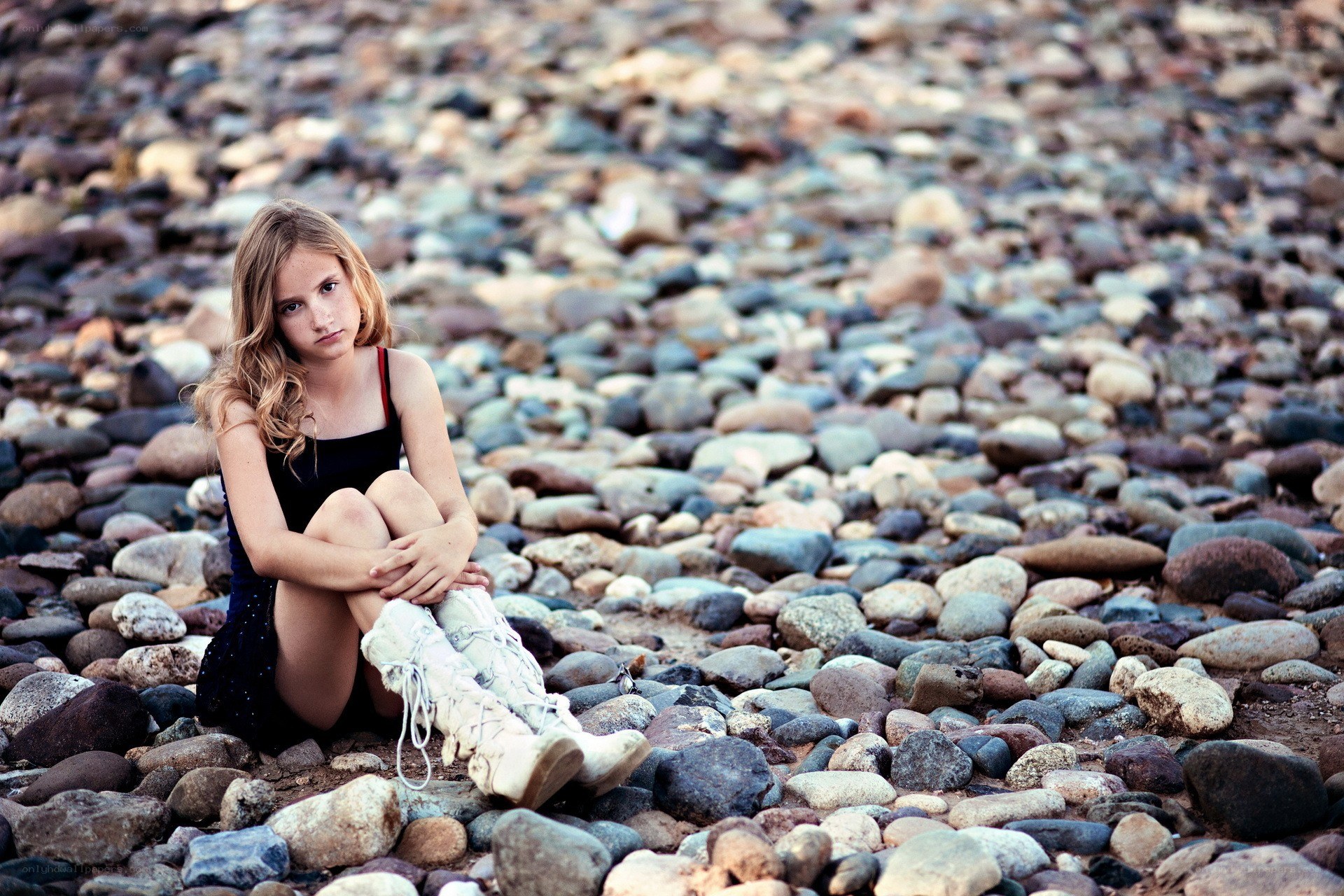 girl sitting on pebbles