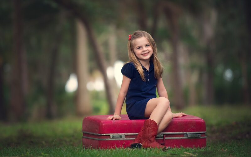 Girl Sitting on Suitcase — Red