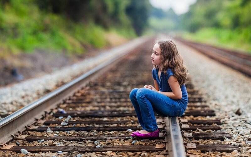 Girl Sitting on Train Tracks — Blue