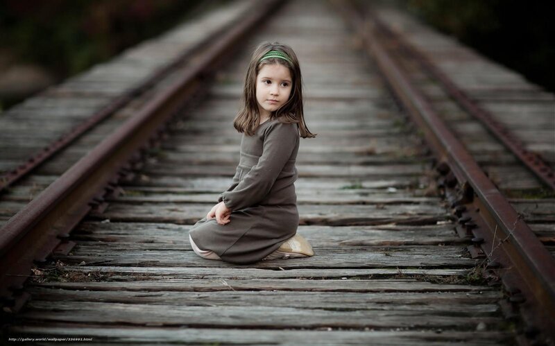 Girl sitting on train tracks