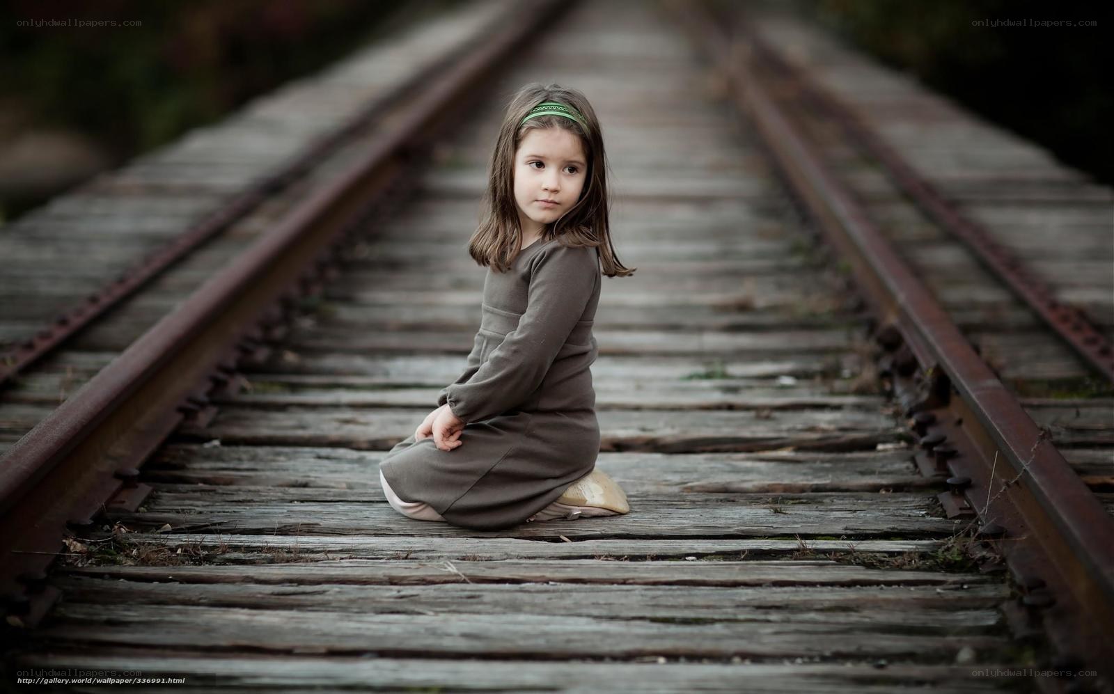 Girl sitting on train tracks
