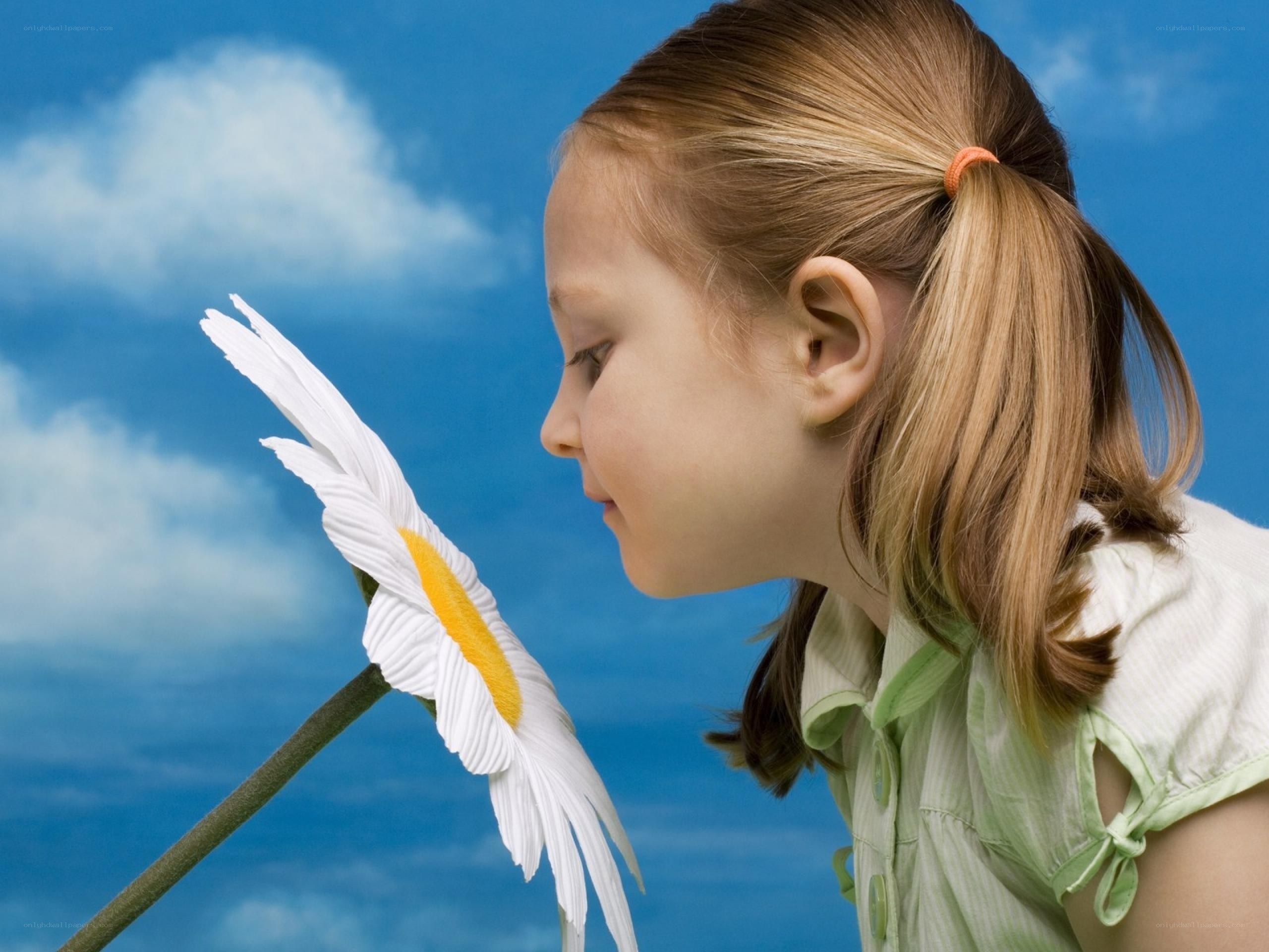 girl smelling a daisy
