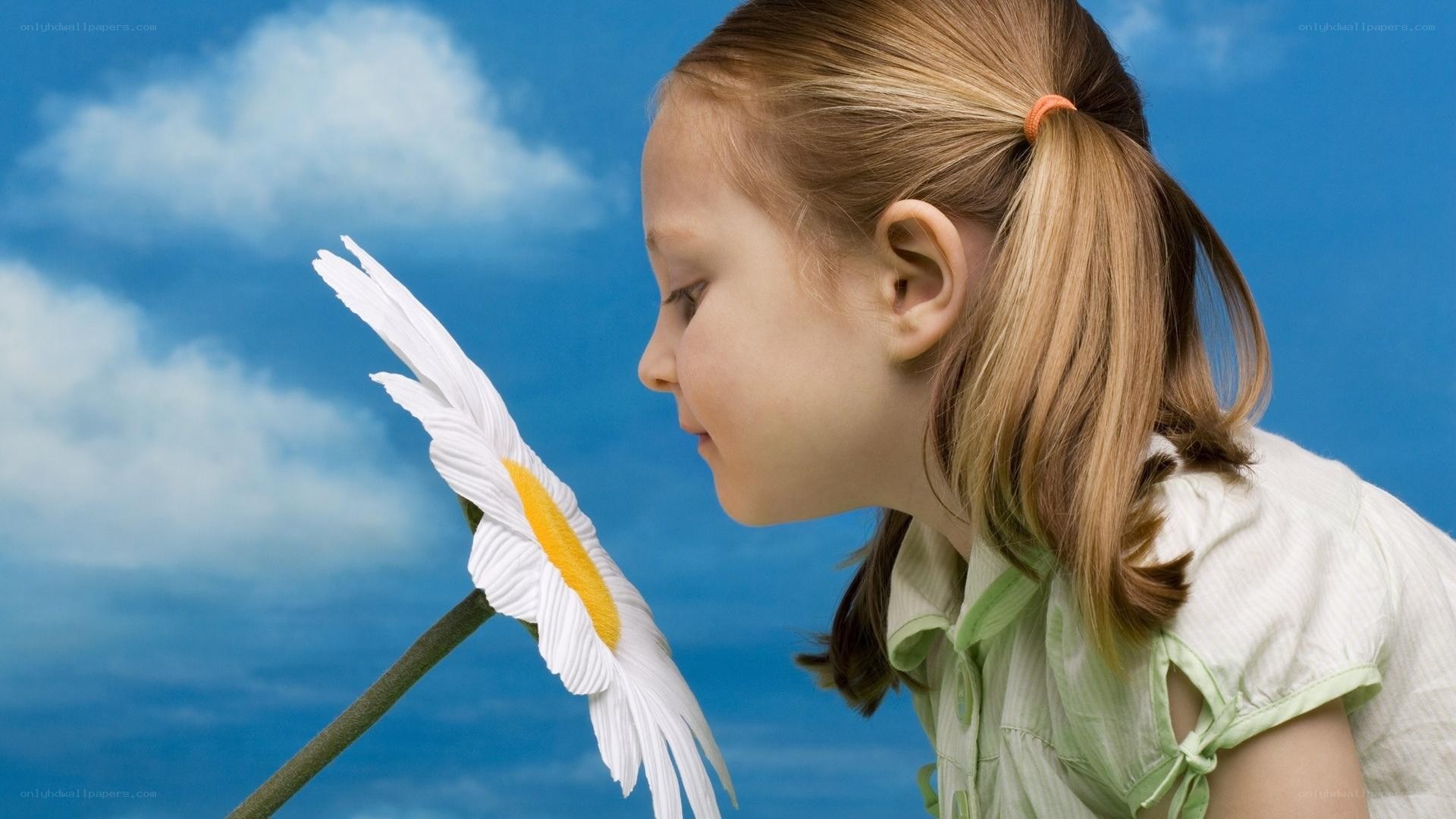 girl smelling a daisy