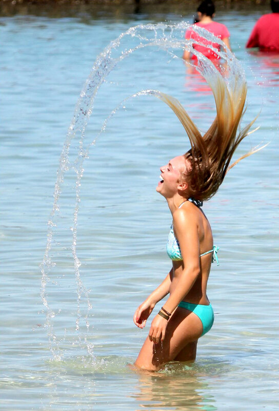 girl splashing water at beach