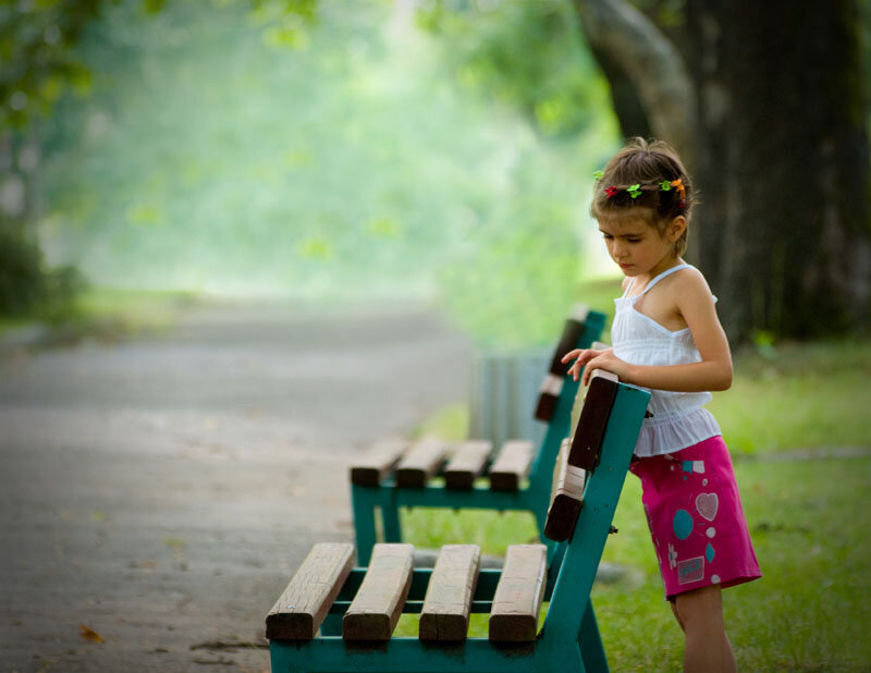 girl standing by park bench