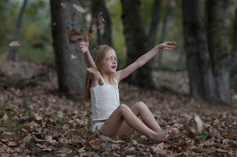Girl Throwing Leaves — Brown