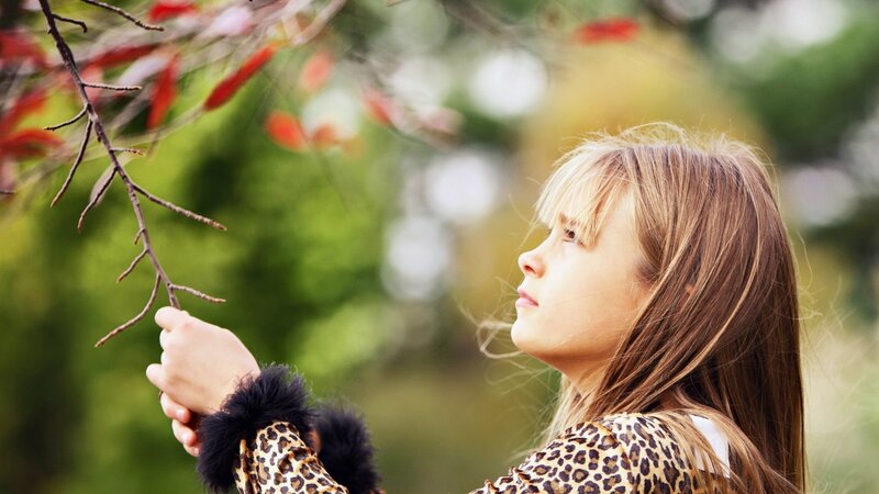 girl touching autumn branch