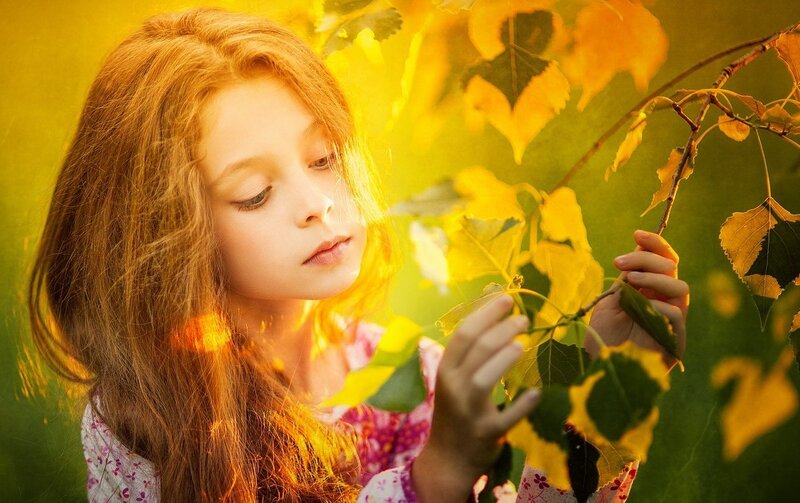 Girl Touching Autumn Leaves
