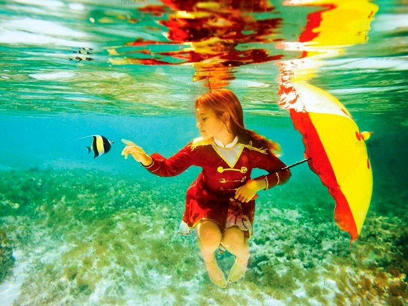 girl underwater with fish