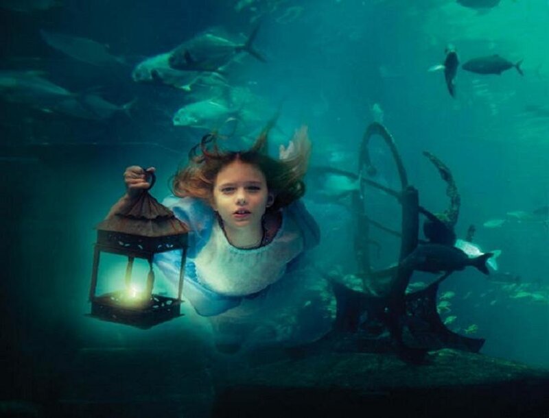 girl underwater with lantern