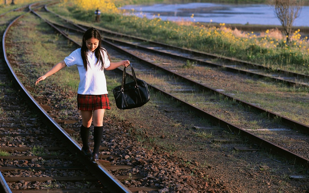 Girl walking on train tracks