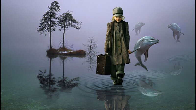 girl walking through water with dolphins