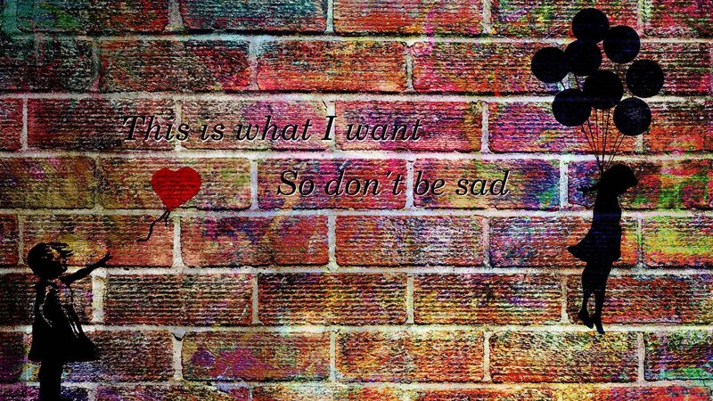 Girl with balloons on brick wall
