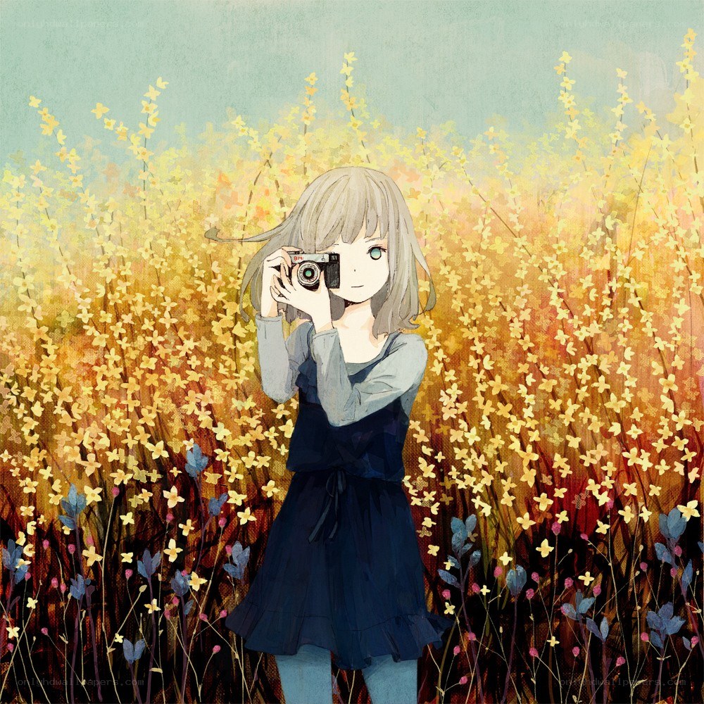 Girl with camera in flower field