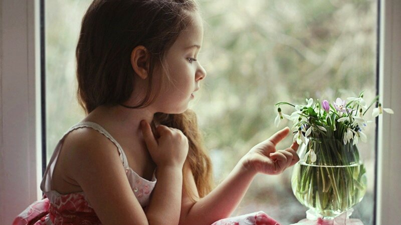 girl with flowers by window