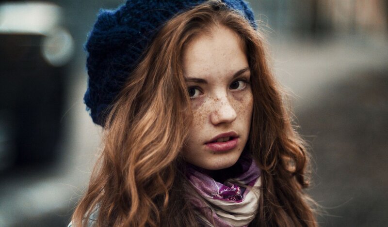 girl with freckles and blue hat