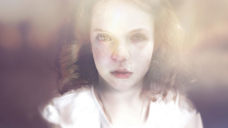 girl with freckles in soft light