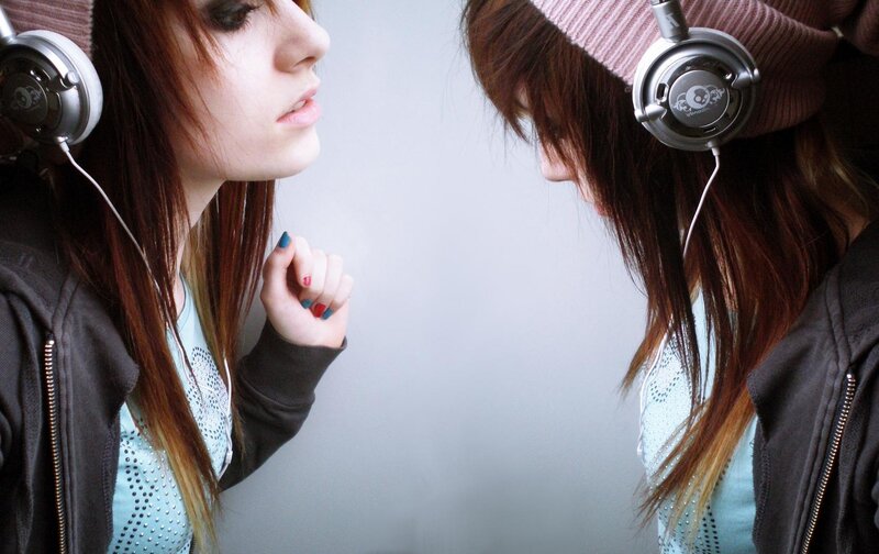 girl with headphones looking at mirror