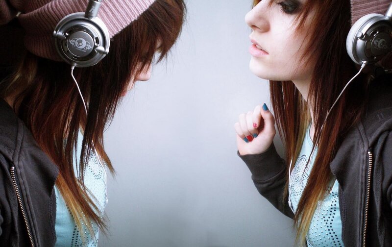 girl with headphones looking at mirror