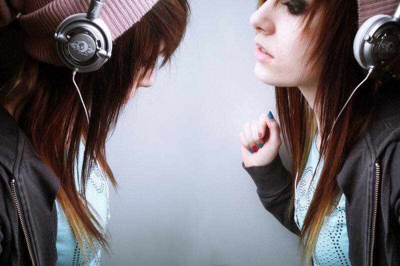 girl with headphones looking in mirror