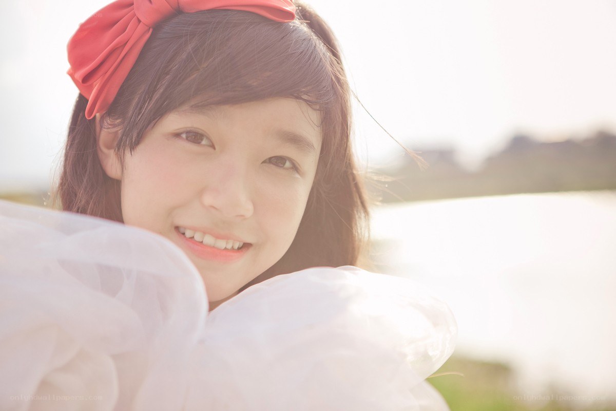 girl with red bow smiling