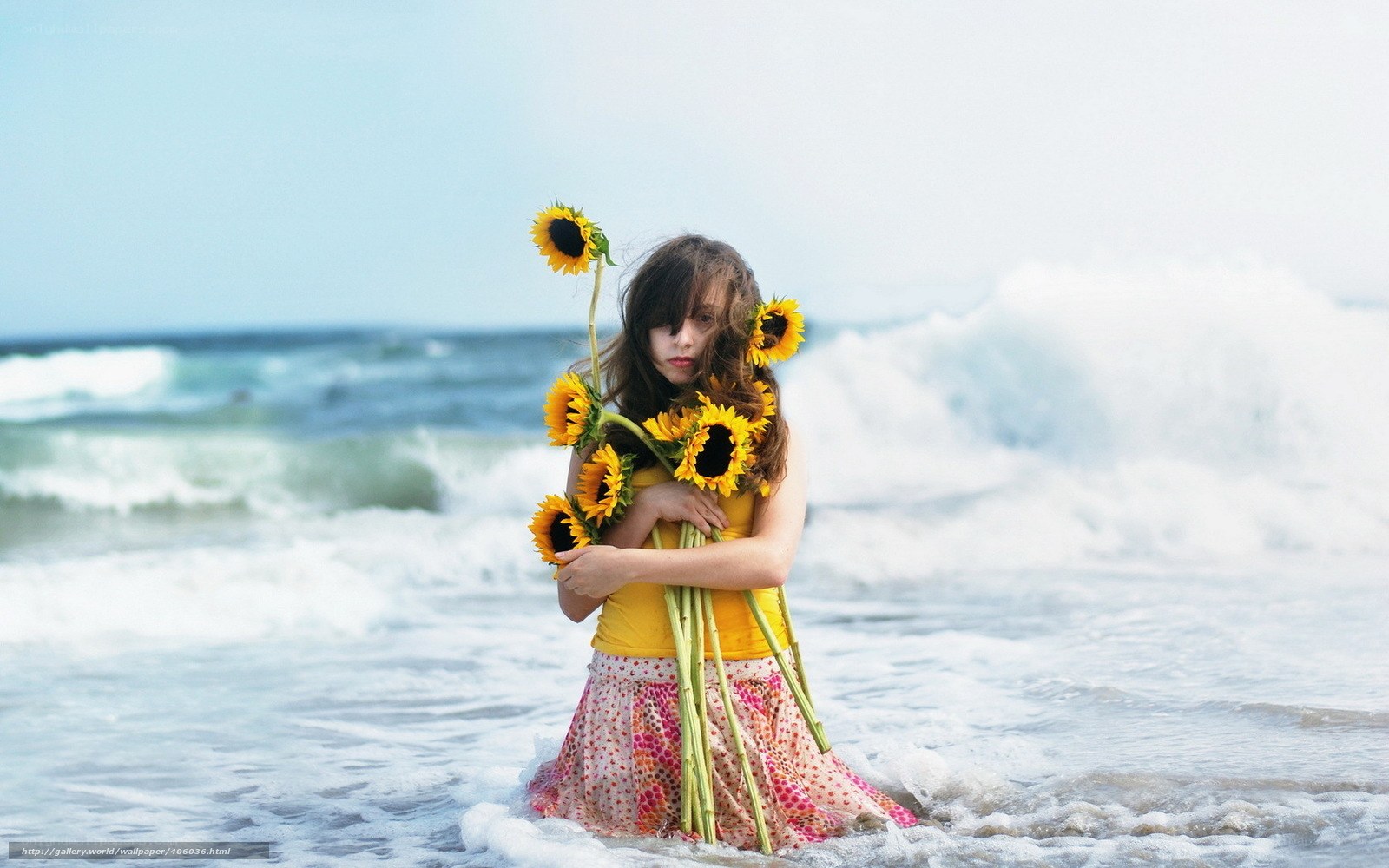 Girl with sunflowers at beach