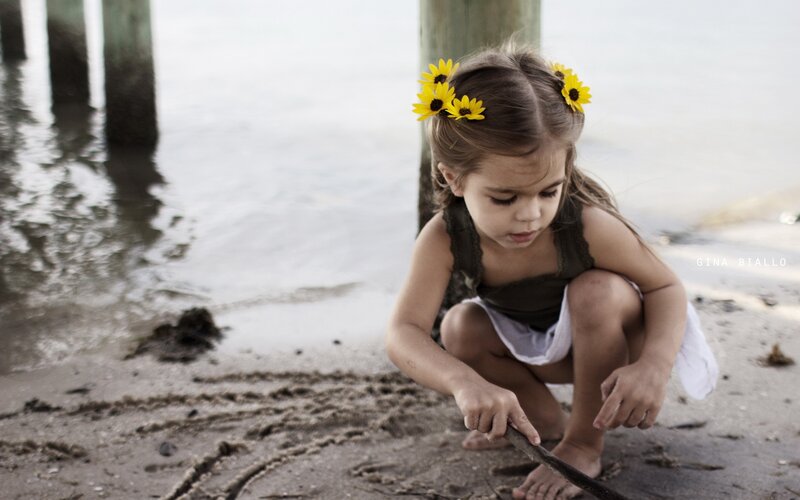 girl with sunflowers at the beach