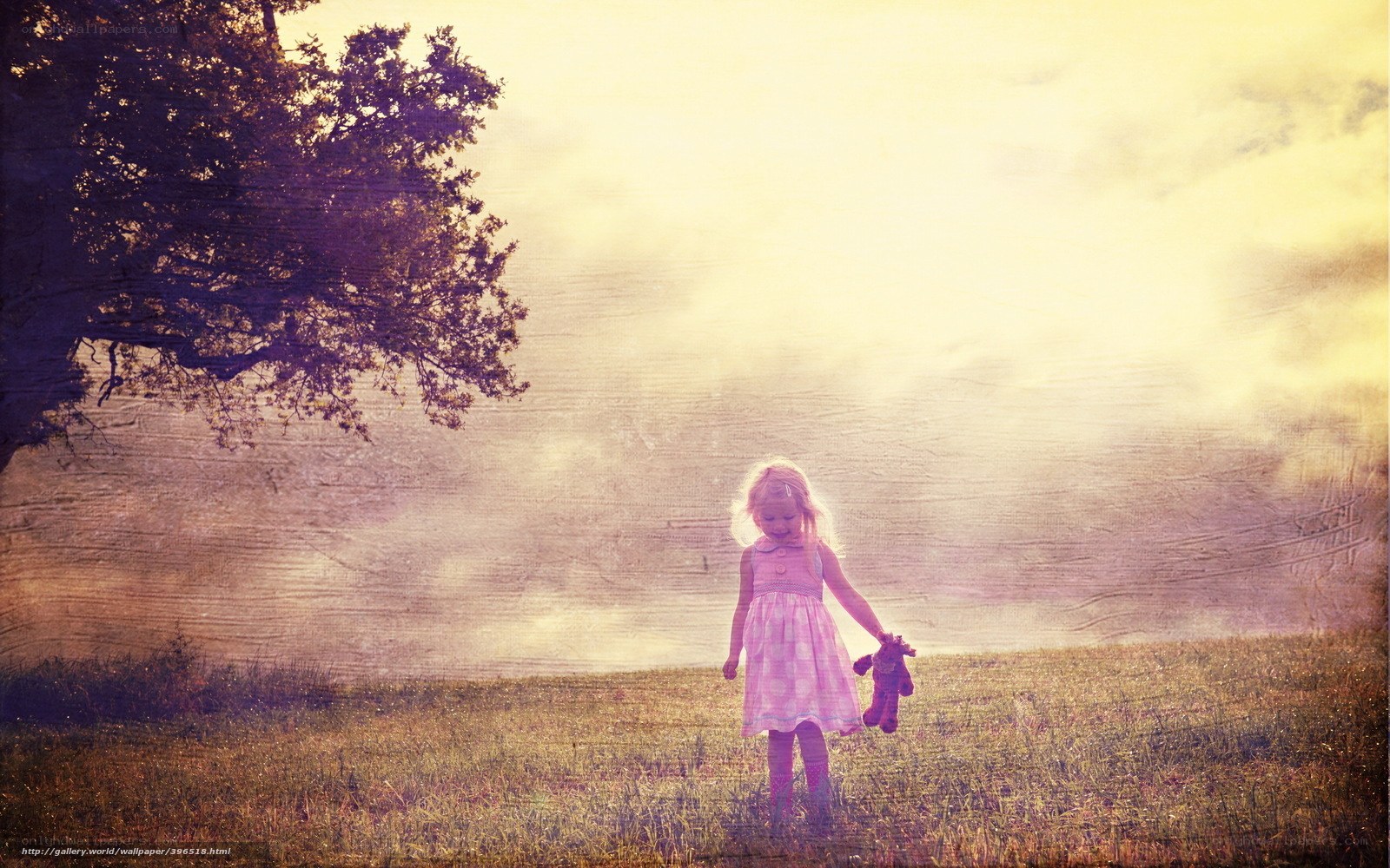 Girl with teddy bear in field