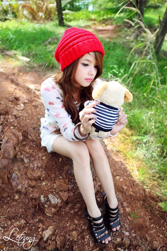 Girl with teddy bear in nature