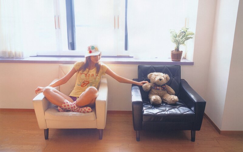 Girl with teddy bear in sunlit room