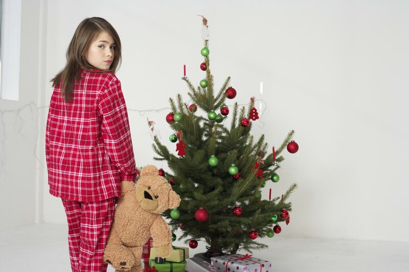 girl with teddy bear near christmas tree