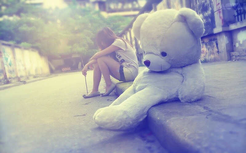 Girl with teddy bear on street