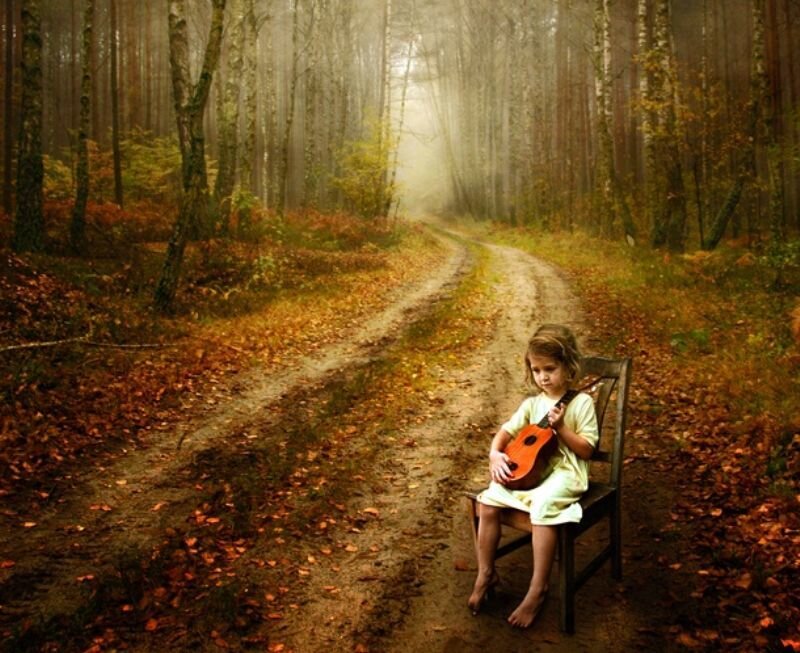Girl with ukulele in autumn forest