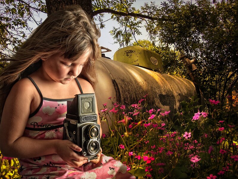 Girl with vintage camera in garden