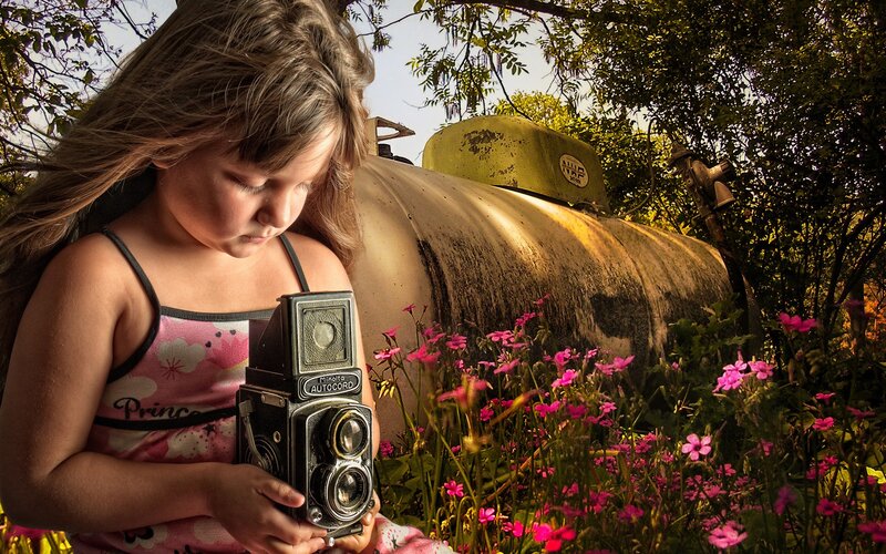 Girl with vintage camera in garden