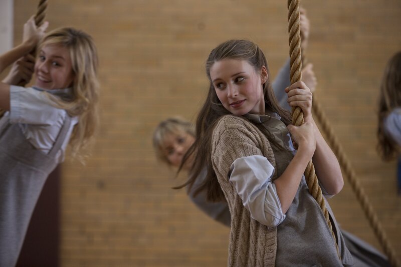 Girls climbing ropes in gym