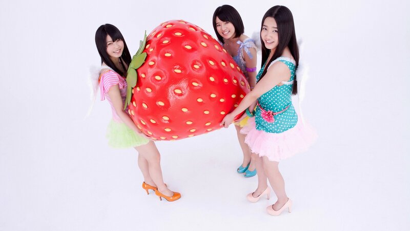 Girls holding giant strawberry prop