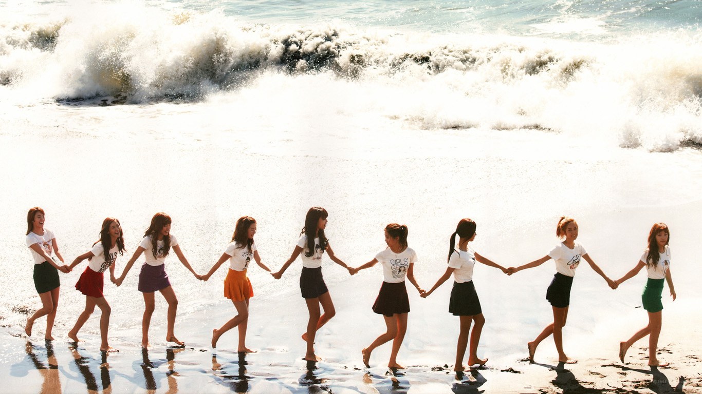 girls holding hands on beach