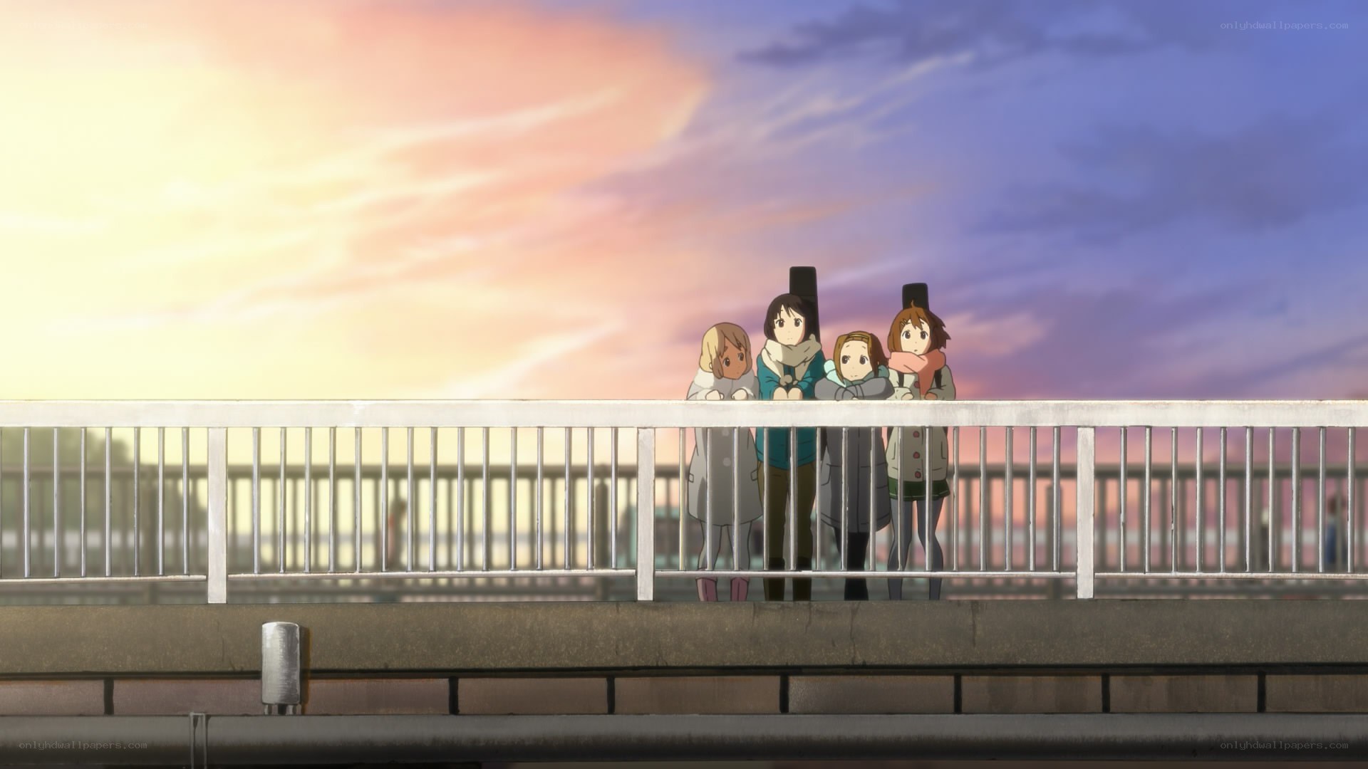 girls on a bridge at sunset