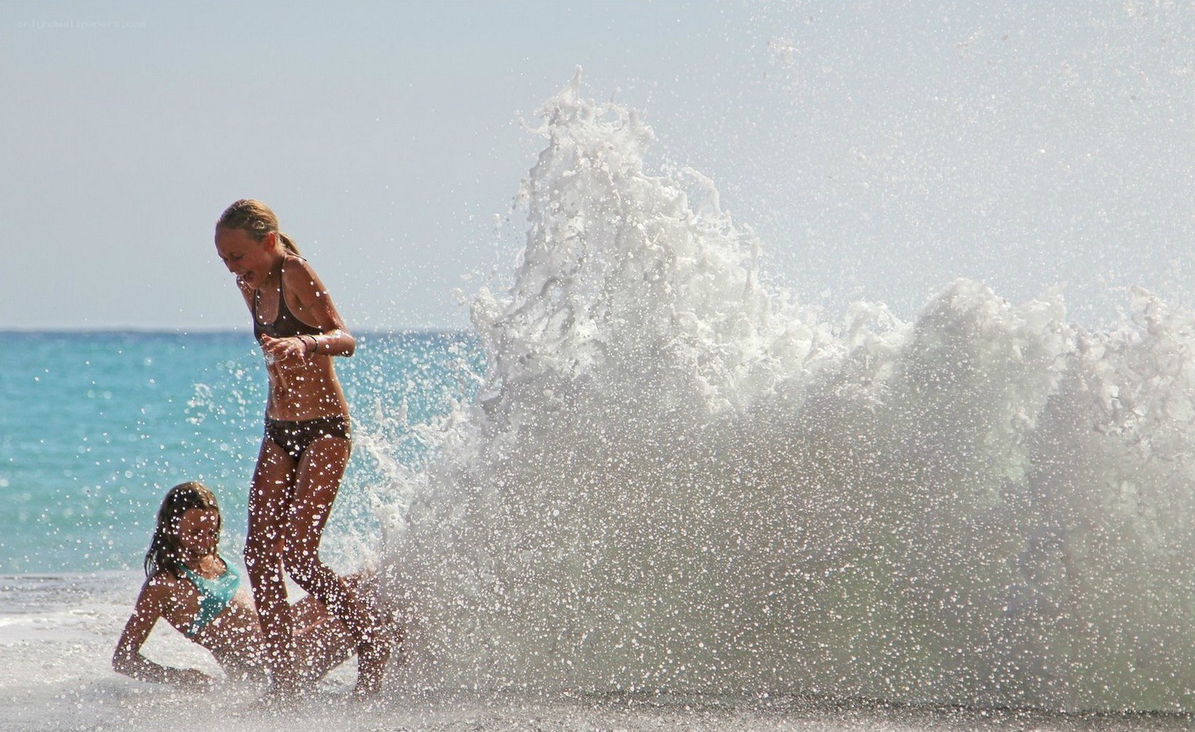 Girls playing in ocean waves