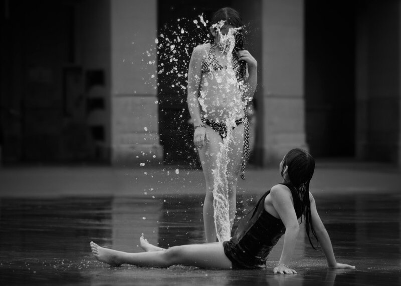 Girls playing in water fountain