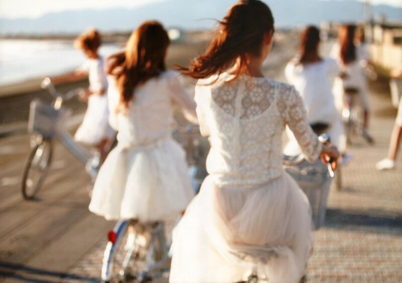 Girls riding bikes by the sea